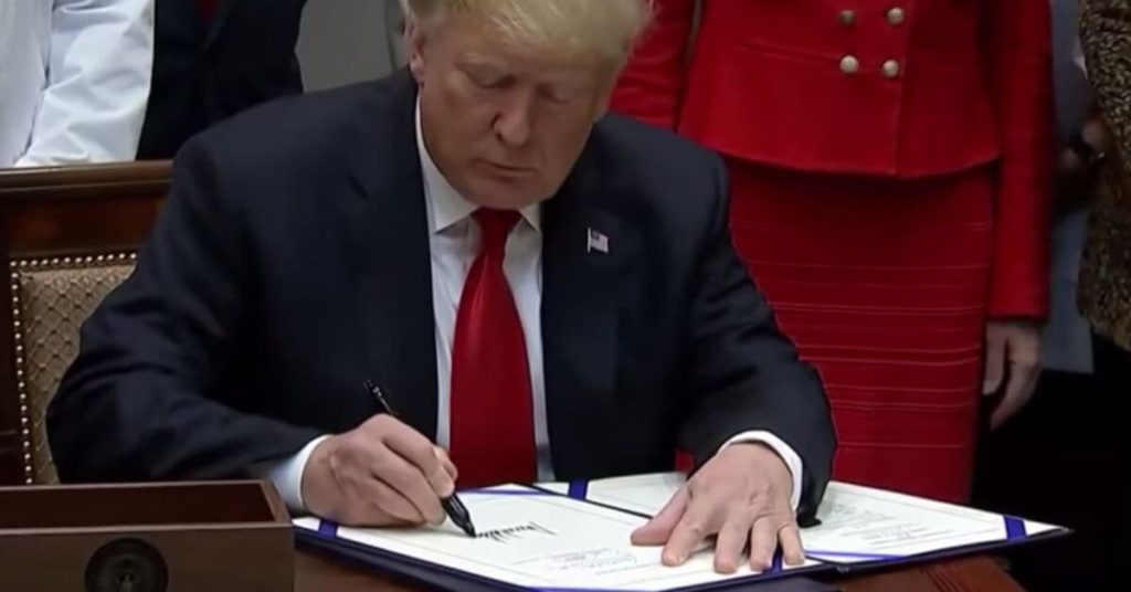 Trump signing document with a Sharpie