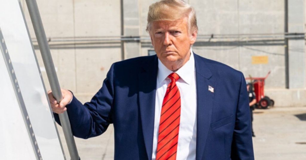 Trump standing on a staircase