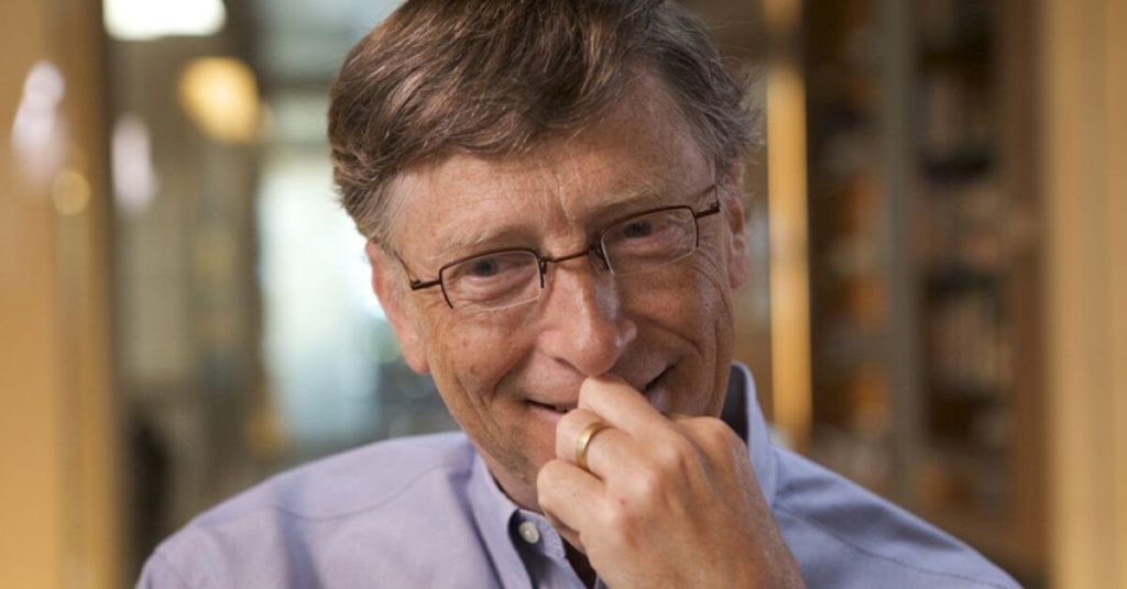 Bill gates holding his hand to his mouth and smiling