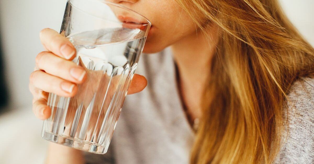 A woman drinking a glass of water