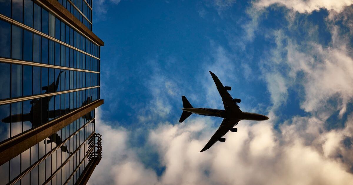 Airplane flying over a skyscraper