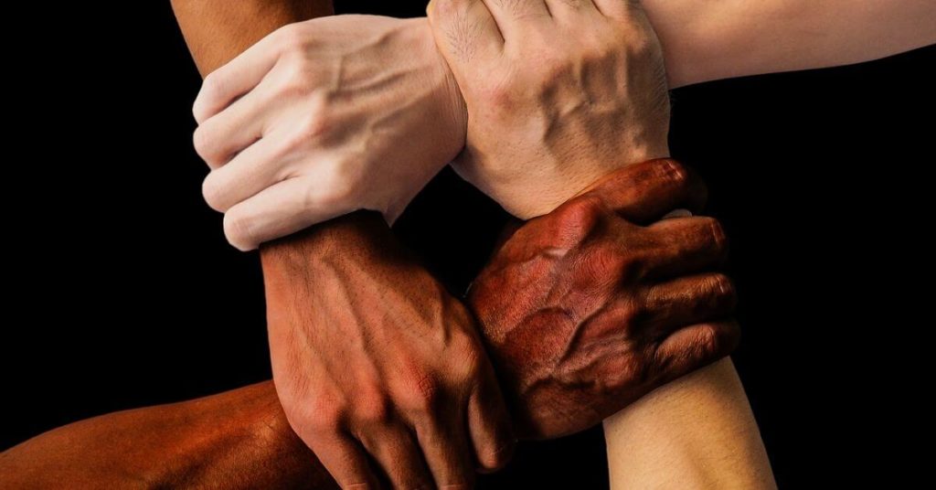 Four hands gripping each other's wrists