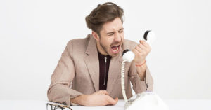 Angry man yelling into the telephone