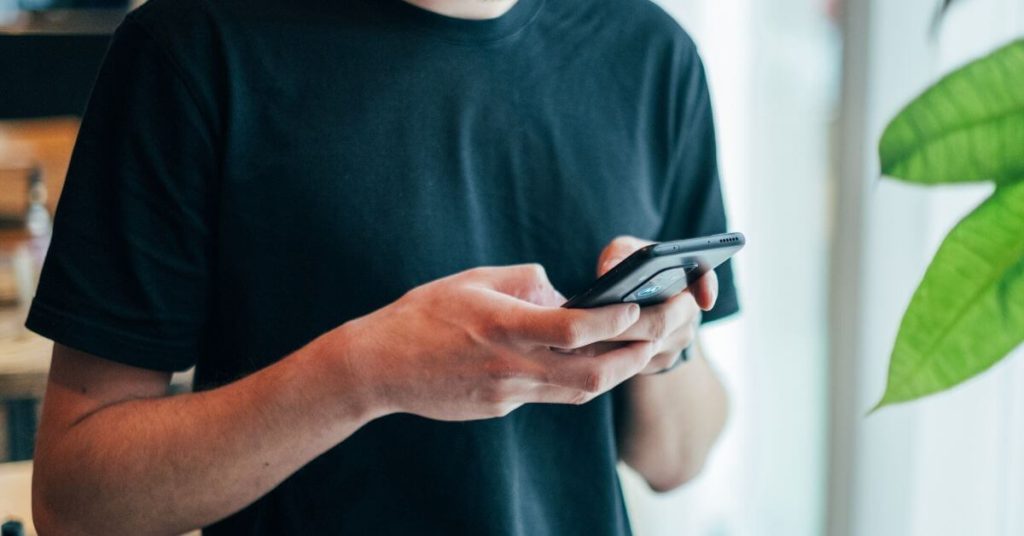 Man in a black shirt holding a phone