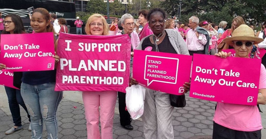 Women holding signs in support of planned parenthood