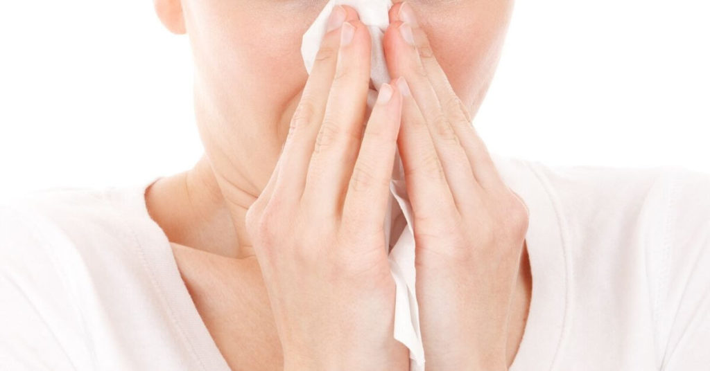 Woman blowing her nose