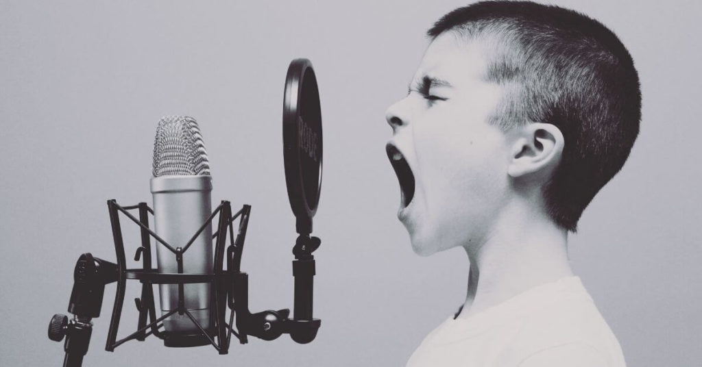 Boy yelling into a microphone