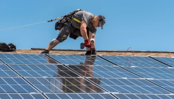 Man installing solar panels to a roof