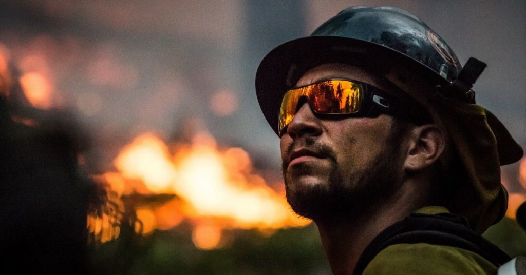 Fireman looking up while a fire rages in the background