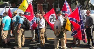 A photograph of men marching with Nazi and Confederate flags.
