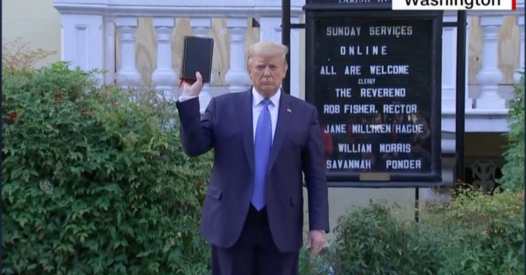 A photograph of Donald Trump holding a bible standing in front of a church