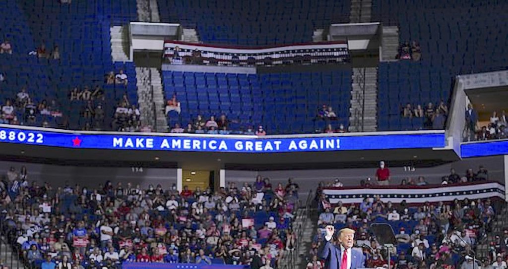 A photograph of Trump speaking to a half empty stadium in Tulsa.