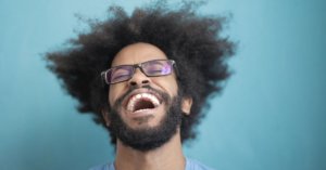 Man laughing in front of a blue background