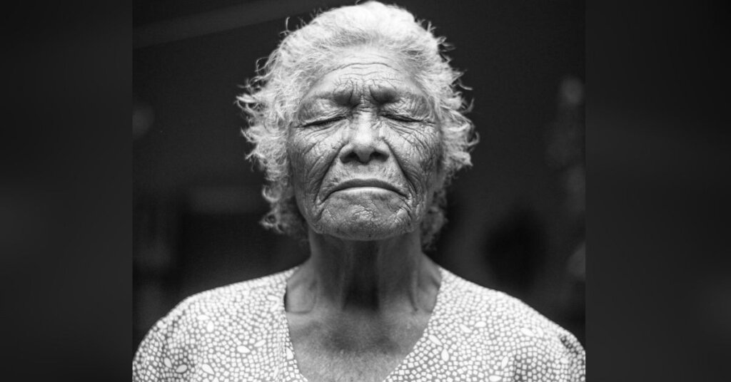 Elderly woman with her eyes closed