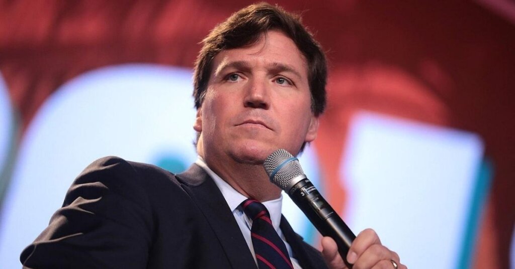 Tucker Carlson holding a microphone