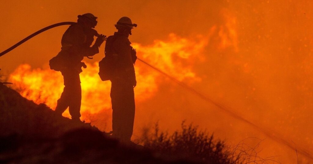 Two fireman putting out a blaze