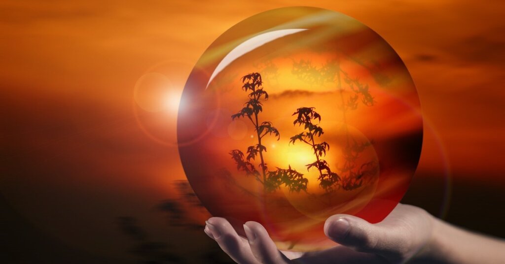 Peering through a crystal ball at a firey landscape.