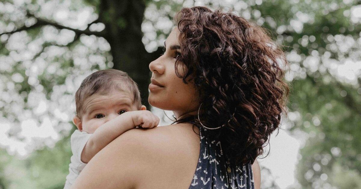 Mother holding her baby outdoors