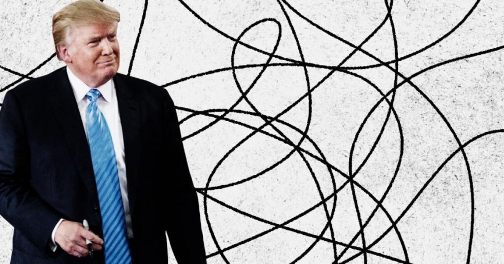 Trump holding a Sharpie standing in front of a scribbled background