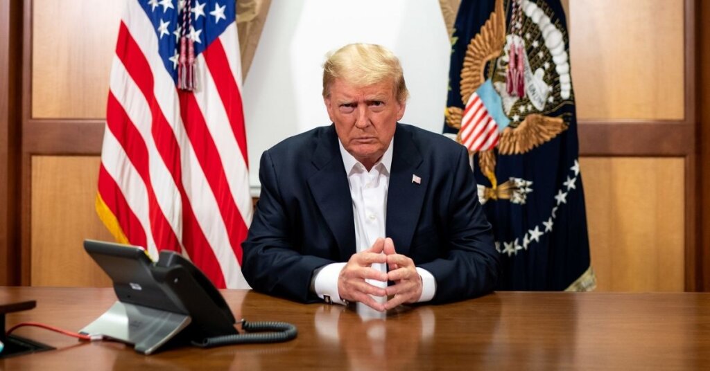 Trump sitting at a table while in Walter Reed