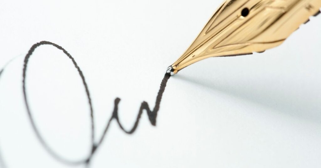 A pen signing a piece of paper