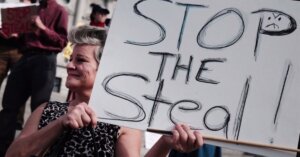 Woman holding 'Stop the steal' sign