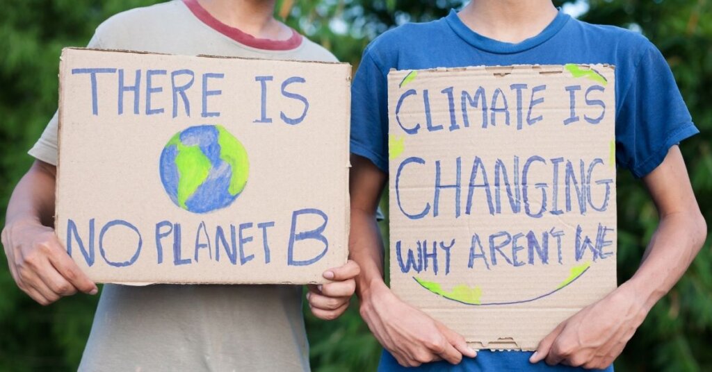 Two children holding climate protest signs