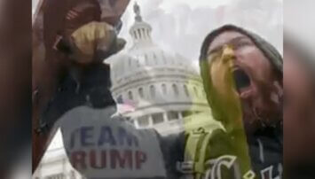 A member of Trump's insurrection screams in front of the US Capitol.