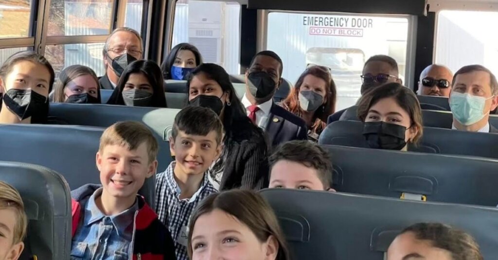 Children and politicians sitting on a school bus